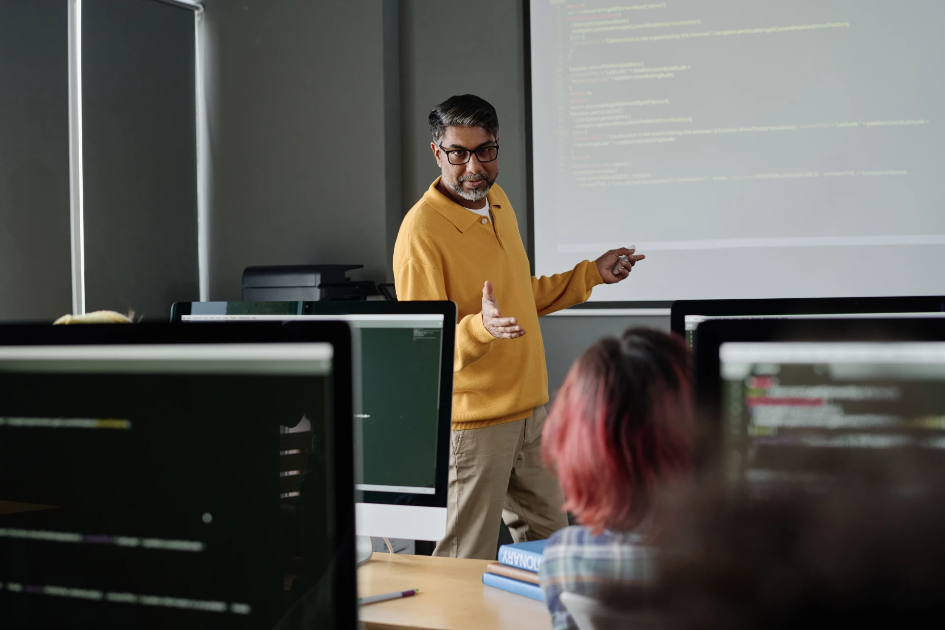 A professor teaching a small class at a whiteboard